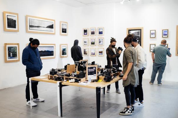 Film cameras on a table in an art gallery.