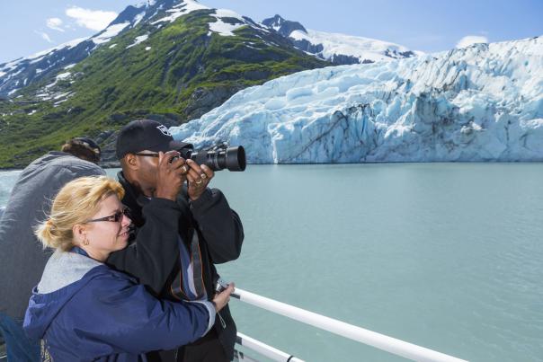 Couple photographs Portage Glacier during glacier cruise