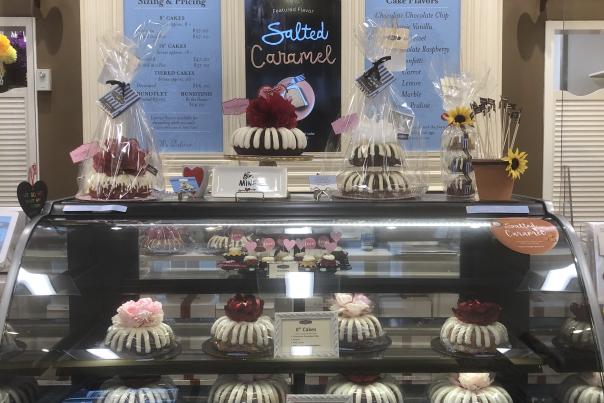 A display case with all size of bundt cakes.
