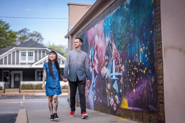 A couple walk by a mural in Five Points.
