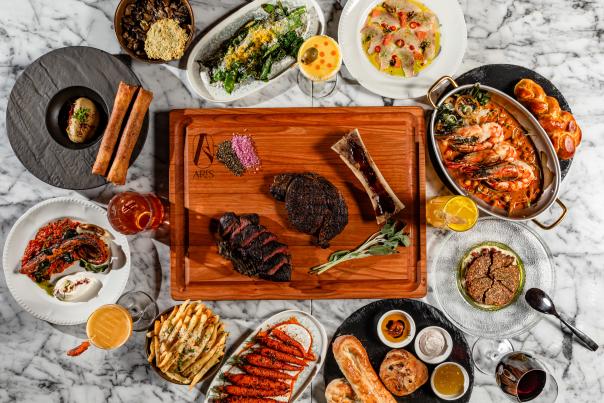 Platters of steakhouse specials including steak, Ceasar salad, bread, large grilled shrimp, grilled vegetables and more.