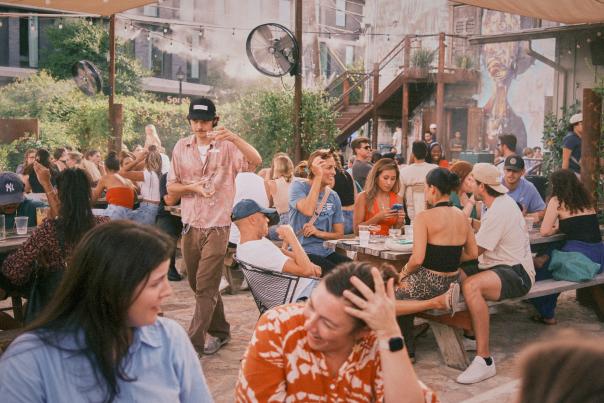 Image of people hanging out and sitting at picnic tables on the outdoor patio at Whisler's.