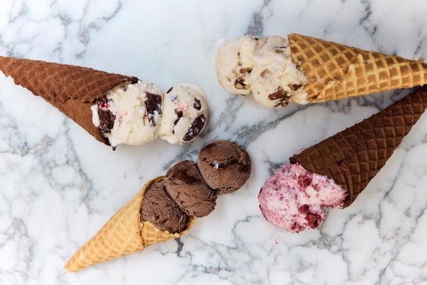 Photo of ice cream cones laying on their side on a white marble countertop.