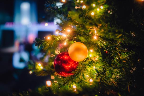 Close-up of a decorated Christmas tree with colorful ornaments and warm lights, creating a festive atmosphere.