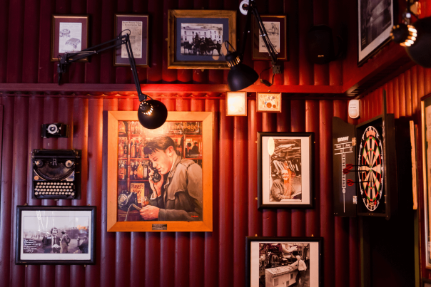 Interior of The Reporter Bar with photos hung on the wall and a dartboard.