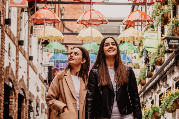 Two women walking through commercial court Belfast.