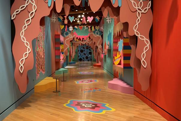 Vibrant installation view at Crystal Bridges Museum featuring colorful cut-out designs and floor graphics by Julie Alpert, embodying a playful and artistic atmosphere.
