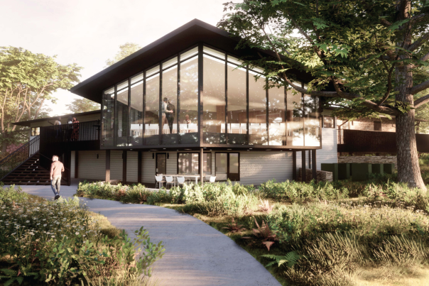 A modern glass building surrounded by lush greenery at the Gardens and Arboretum in Bentonville.