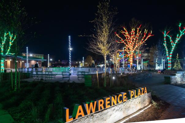 Lawrence Plaza lit up at night with the ice skating rink in the background