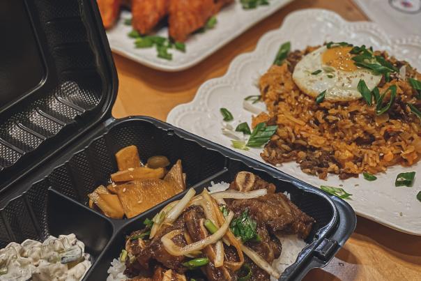 To-go box with white rice, meat, and garnishes offered at ArkanSeoul