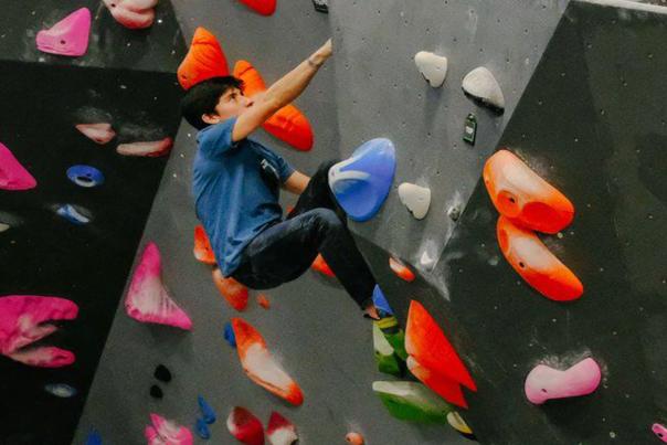 Image of a young boy climbing on an indoor rock climbing wall