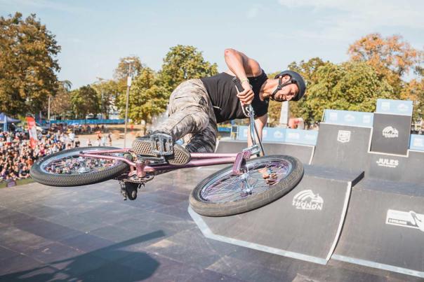 A BMX rider performs a trick in front of a crowd