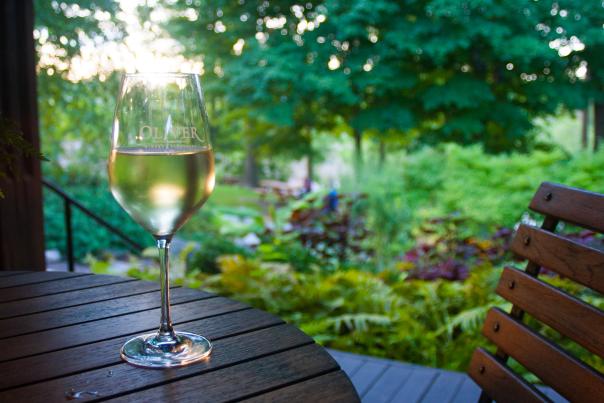 Glass of white wine sitting on a table outdoors at the Oliver Winery in Bloomington, IN