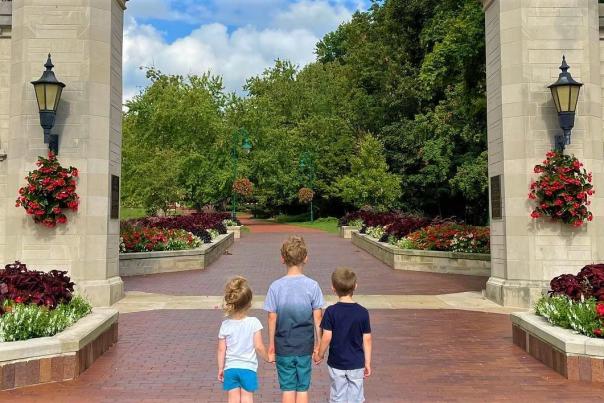 Three small kids standing at Sample Gates while holding hands