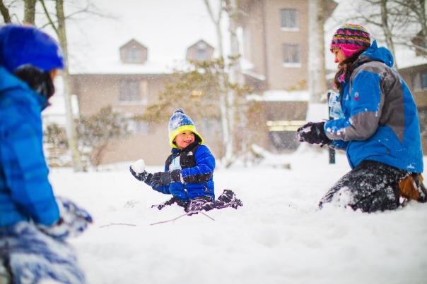 A child raises their arm with a snowball ready to throw!