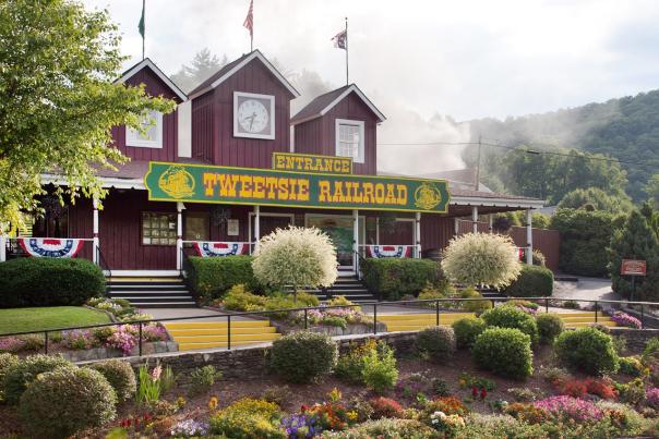 The entrance to Tweetsie Railroad Wild West Theme Park, with steam from the locomotives rising above the building from behind.