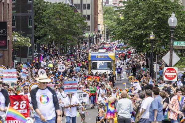 people walking down the street in celebration of the Pride Parde. featuring the mobile VIC.