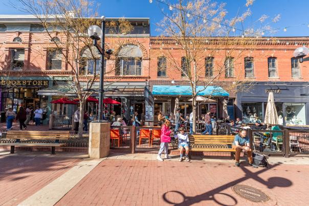 A scene of Pearl Street with people enjoying the sunshine amidst shops, restaurants and more