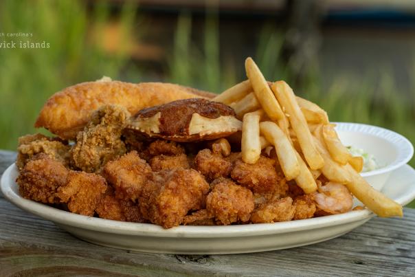 A plate of fried seafood and french fries