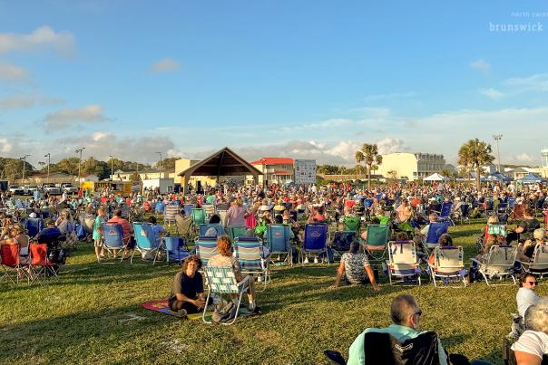 a crowd of people attending an outdoor concert on Oak Island, NC
