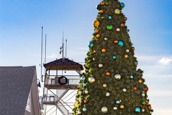 A decorated Christmas tree in Southport, NC with a pilots tower visible in the background