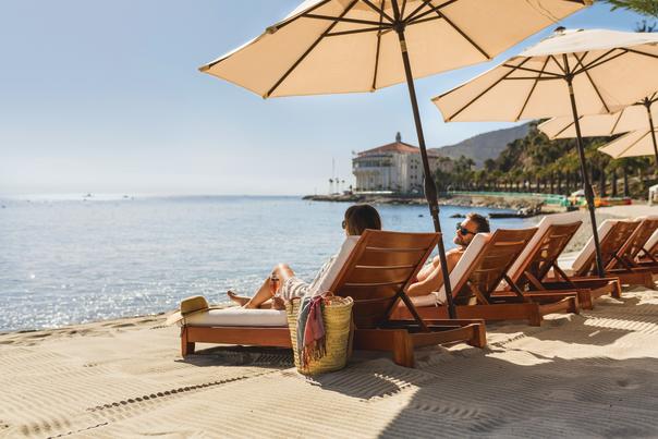 Woman Sitting On Descanso Beach Club Chaise Lounges On Catalina Island