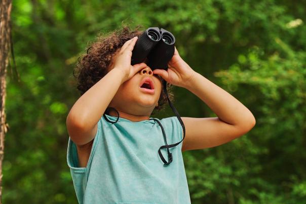 kid looking through binoculars