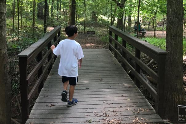 Child walking across bridge at Poet's Walk