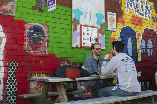 People sitting at Picnic Table Midway Mural on Graham St