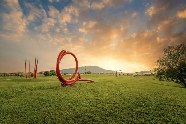 Image of field of sculptures as the sunsets, lookout mountain in the background