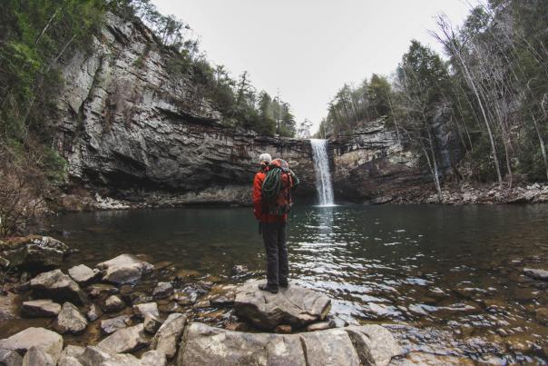 Person stands in front of Foster Falls in Winter
