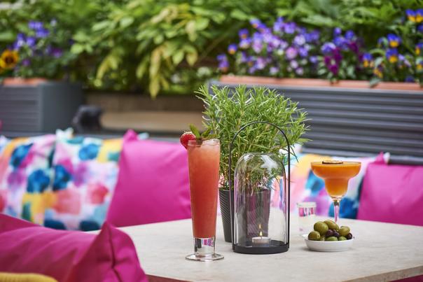 Image shows a table decorate with candle, lantern and olives
