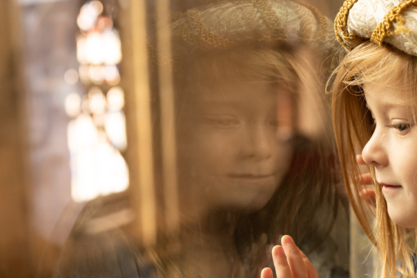 A girl looking through the glass at Gloucester Cathedral