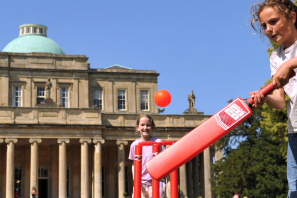 Children playing cricket outside Pittville Pump Room in Cheltenham