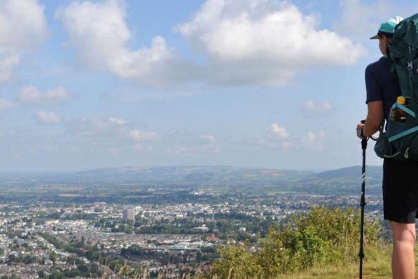 A person wearing hiking gear looking over Leckhampton Hill, Cheltenham.