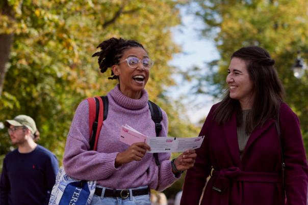 Visitors at Cheltenham Literature Festival reading the programme, by Cheltenham Festivals.
