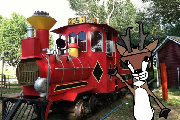 Illustrated pronghorn antelope Andy Lope stands in front of the red train engine at Terry Bison Ranch
