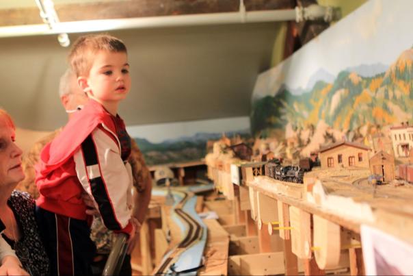 Young child observing detailed model train display at Cheyenne Depot Museum, an kid-friendly indoor activity.
