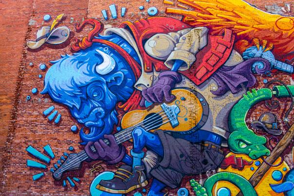 A mural of a blue bison playing the guitar in Cheyenne's art scene.