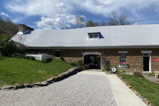 Image is the outside, front facade of the Baker Bird Winery with wooden barrel out front that say's "Baker Bird".
