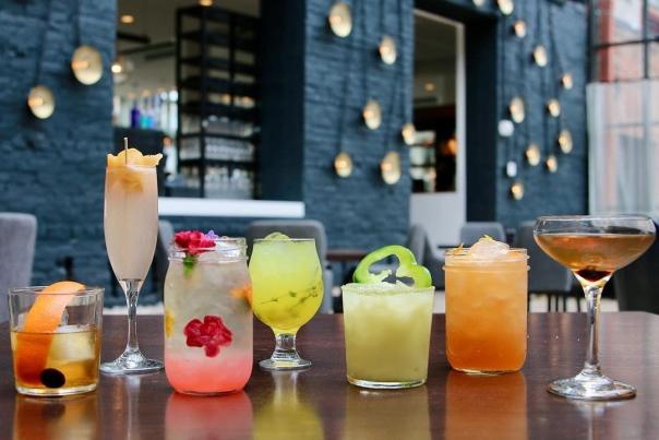 A row of various cocktails, colored pink, yellow, amber and green at Coppin's Restaurant in Covington, Ky.