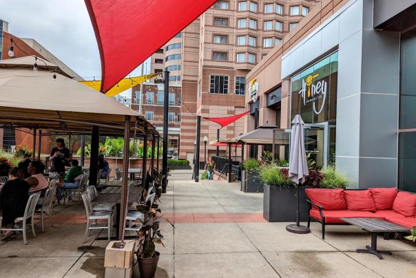 Outside patio of Honey Uninhibited featuring outdoor couches, tables and chairs.