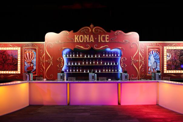 A brightly colored bar in pink, orange and blue with a sign that says Kona Ice