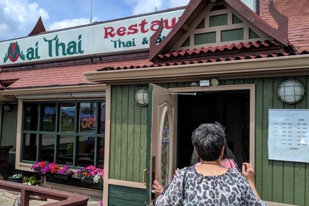 A woman entering the doorway of Mai Thai restaurant in Florence, Ky.