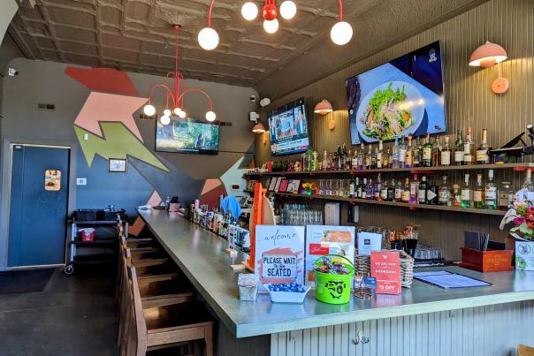 Image is of inside Thai Pavilion looking at the bar area with chairs and beer behind the counter.