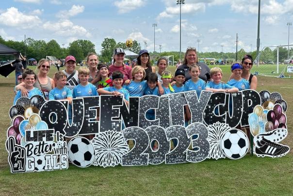 girls and women post behind Queen City Cup 2023 sign