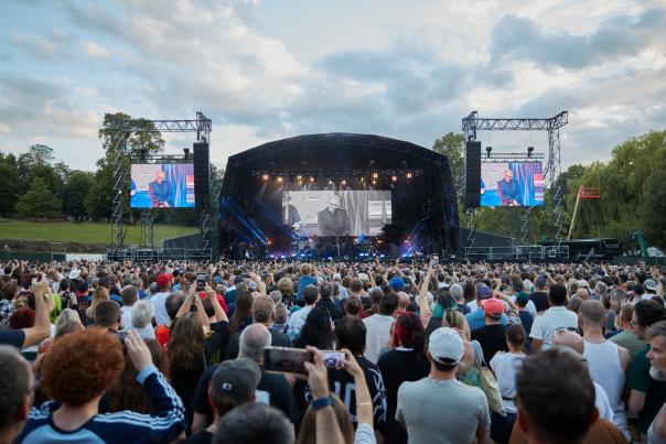 A crowd is formed in front of a large stage.