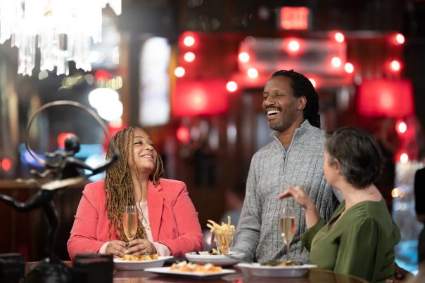Three people laughing in a restaurant