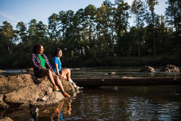 Two women sitting on the bank of the Saluda River