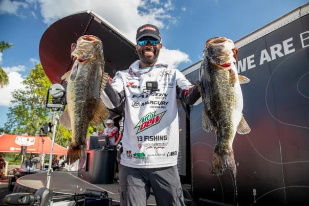 Smiling angler holding up two large fish